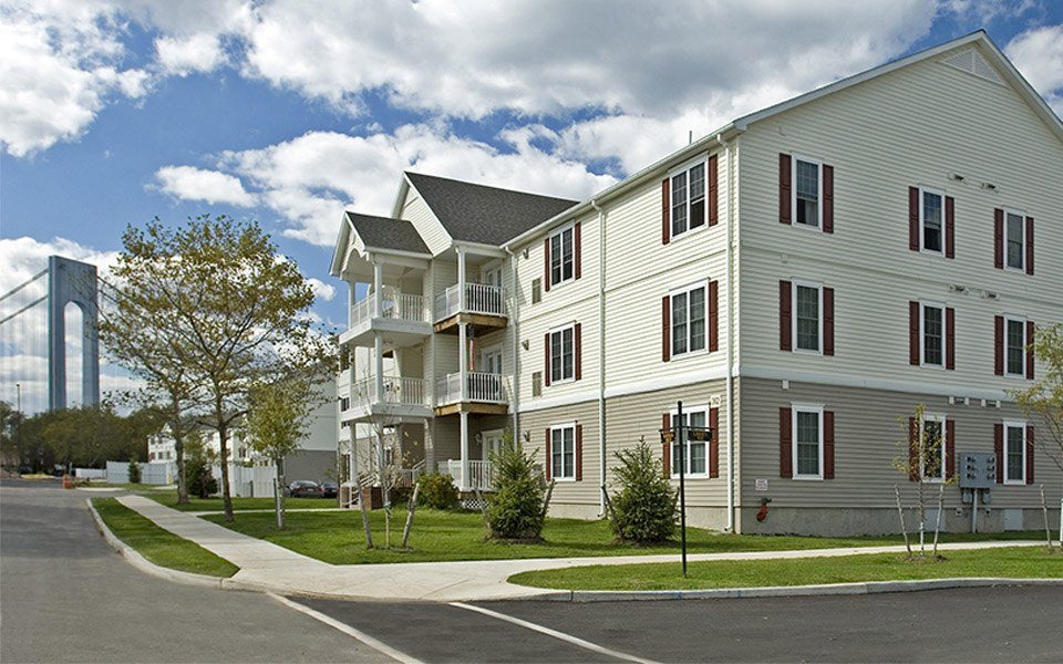 an apartment complex with a large tower in the background